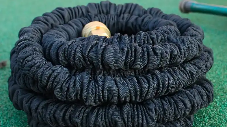 black expandable garden hose on the ground