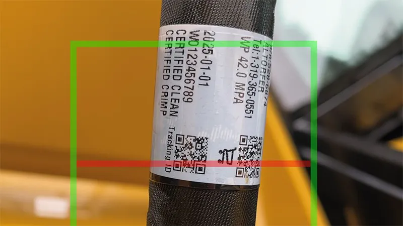 technician scanning QR code label on hydraulic hose